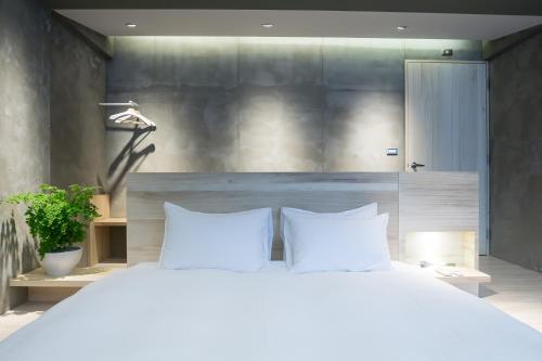 a bedroom with a large white bed with two pillows at Shaoguang 188 in Yuchi