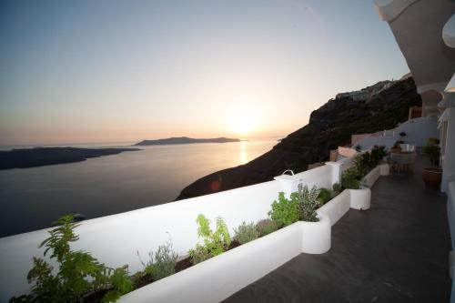 a view of the ocean from a villa with the sunset at Fanari Vista Suites in Fira