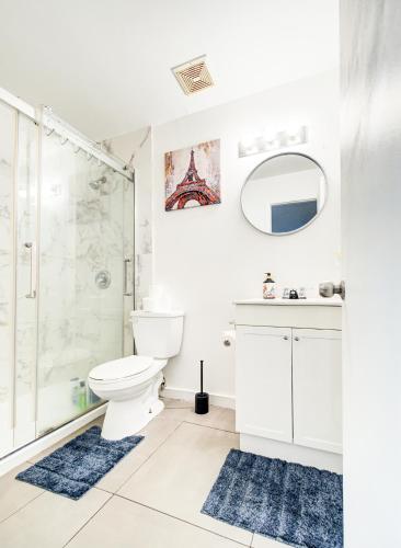 a white bathroom with a shower and a toilet at Séjour agréable à Griffintown 2 chambres in Montréal