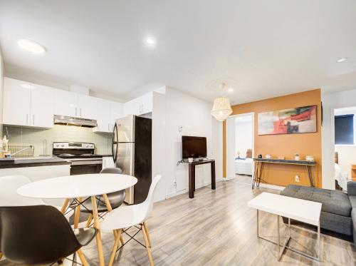 a kitchen and living room with a table and chairs at Séjour agréable à Griffintown 2 chambres in Montréal
