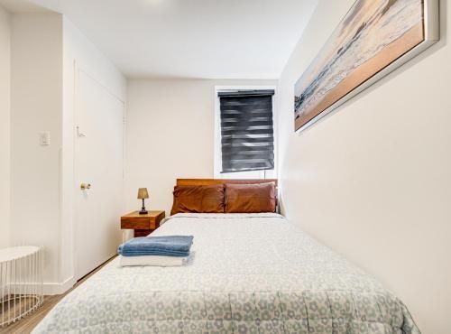 a bedroom with a bed and a window at Séjour agréable à Griffintown 2 chambres in Montréal