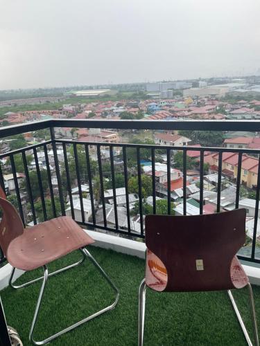 two chairs sitting on top of a balcony at Deluxe Studio Condo Royal Oceancrest Mactan in Mactan Island
