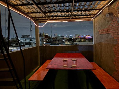 バンコクにあるNomad Yard Hostelのバルコニーの上にグラス2枚付きのテーブル