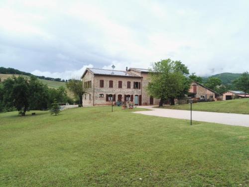 an old stone building with a large grass field at Da Foschetta in Matelica