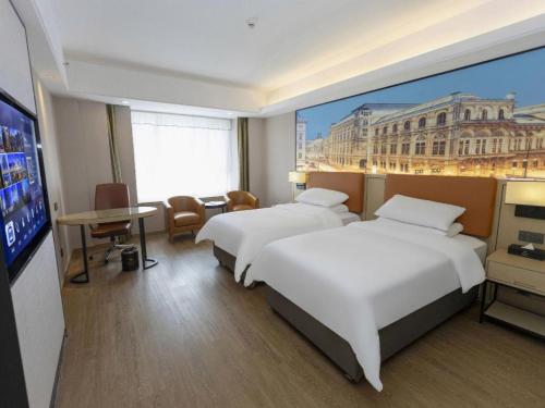 une chambre d'hôtel avec deux lits et une télévision à écran plat dans l'établissement Vienna Hotel Shandong Jinan High-Tech Wanda Exhibition Center, à Jinan