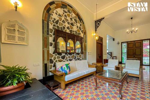 a living room with a couch and a table at StayVista at Villa Harmony with Bonfire, Pool in Alibaug