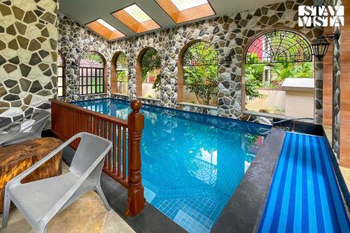 a swimming pool in a house with a tile wall at StayVista at Villa Harmony with Bonfire, Pool in Alibaug