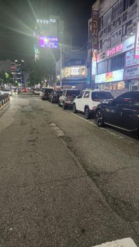 a row of parked cars on a city street at night at Time Stay in Busan