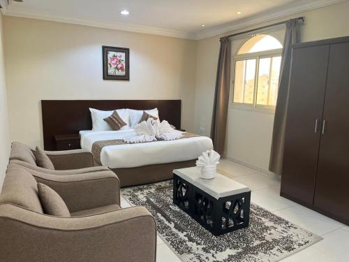a bedroom with a bed and a couch and a table at فندق ريست ان الربوة in Medina
