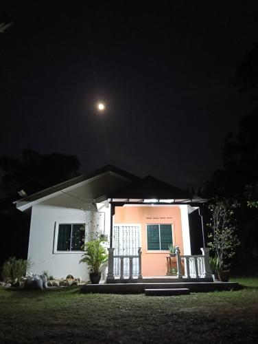 a small house at night with a moon at Air Puteri Rest House in Mersing