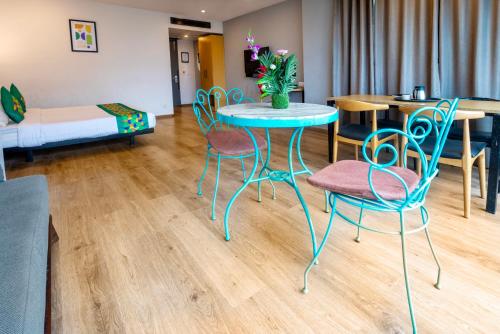 a room with a table and chairs and a bed at Treebo Terrazzo Suites in Ahmedabad