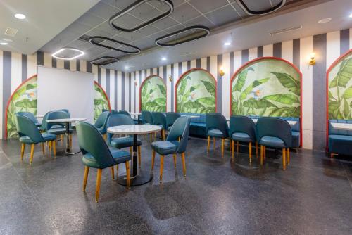a waiting room with blue chairs and tables and a whiteboard at Treebo Terrazzo Suites in Ahmedabad
