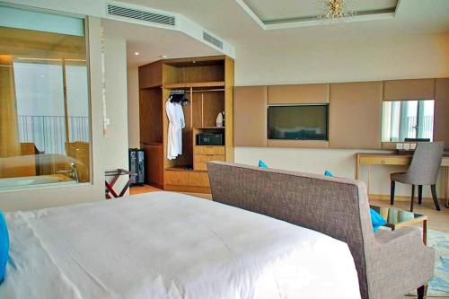 a bedroom with a large white bed and a kitchen at S79 Residence LYN Panorama in Nha Trang