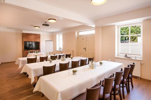 a conference room with tables and chairs and a window at Hotel Zur Burg GmbH in Burg Stargard