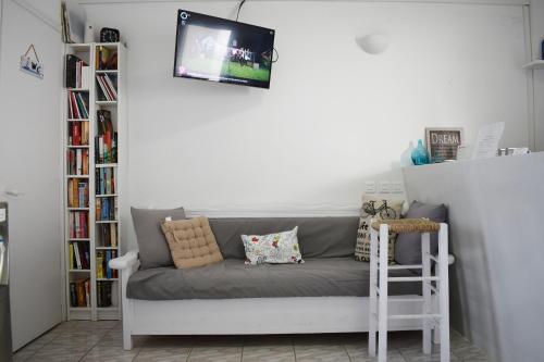 un divano in un soggiorno con TV a parete di Zacharakis Studios a Kamari