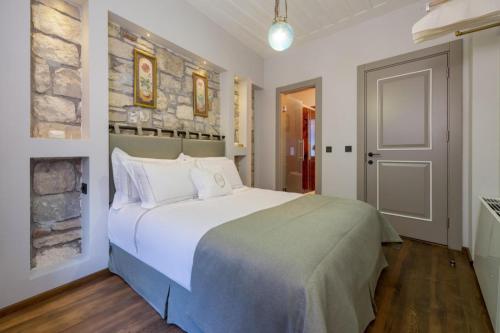 a bedroom with a large bed and a stone wall at Zoi Urla in Urla