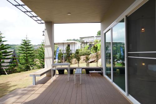 a porch of a house with a bench on it at บ้านผูกรัก ทะเลหมอก ณ เขาค้อ in Khao Kho