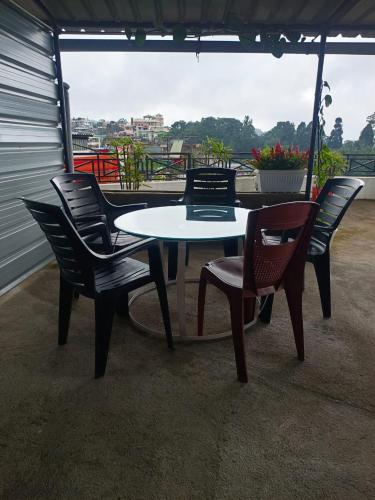a table and chairs on a patio with a view at Mawdong Homestay in Shillong