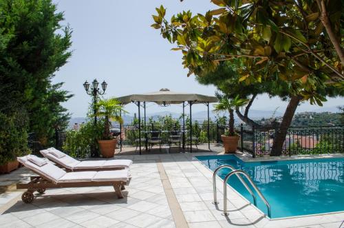 a pool with two lounge chairs and a umbrella at Apartments Nina in Athens