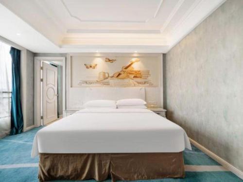 a bedroom with a large white bed in a room at Vienna Hotel Guiyang Jiaxiulou Jichang Road in Guiyang