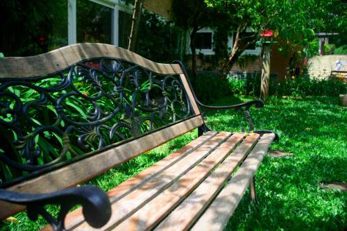a wooden park bench sitting in the grass at La Réserve Suites in Monte Verde