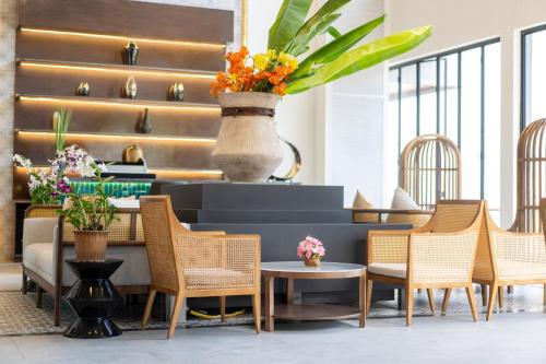 a lobby with chairs and a table and a vase with flowers at Howard Johnson by Wyndham Phuket Naiyang in Thalang