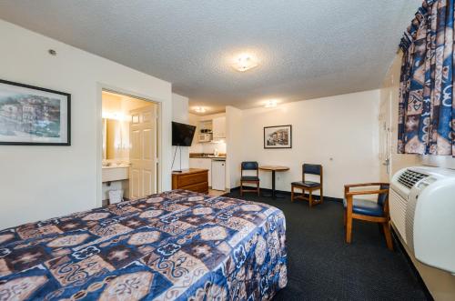 a hotel room with a bed and a table and chairs at Tampa Bay Extended Stay Hotel in Largo