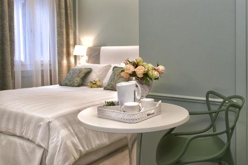 a bedroom with a bed with a table and a bed with flowers at Aquamare, boutique b&b in Venice
