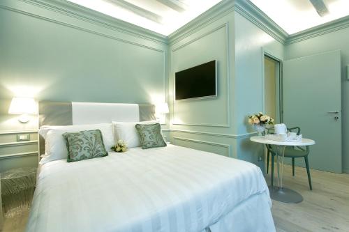 a white bedroom with a white bed and a table at Aquamare, boutique b&b in Venice
