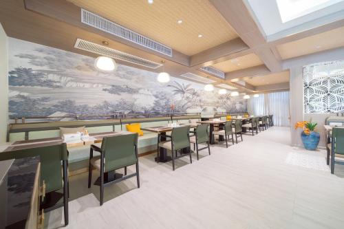 a rendering of a restaurant with tables and chairs at Howard Johnson by Wyndham Phuket Naiyang in Thalang