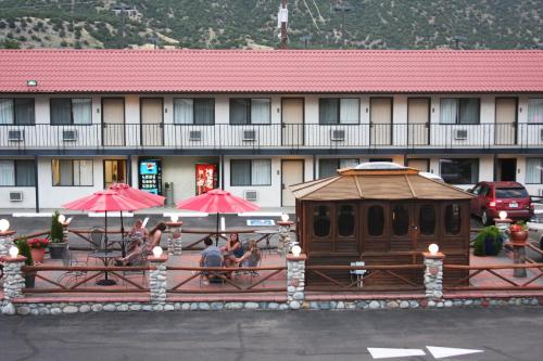 a group of people sitting under umbrellas in front of a hotel at Gateway Inn and Suites in Salida