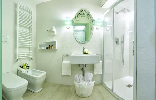 a bathroom with a sink and a toilet and a mirror at Aquamare, boutique b&b in Venice