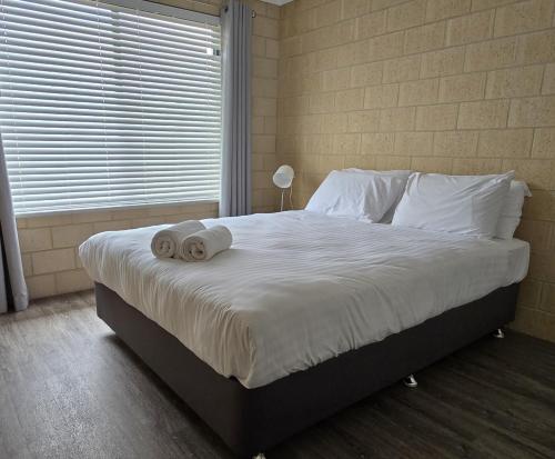 a bedroom with a large bed with towels on it at Esperance Break Away in Esperance