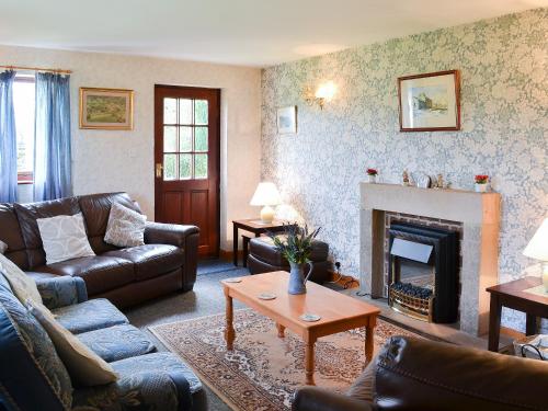 ein Wohnzimmer mit Sofas und Kamin in der Unterkunft Yarker Lane Cottage in Mickleton