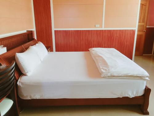 a bed with white sheets and pillows in a room at Mingyuan Homestay in Jinhu