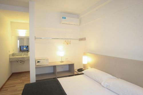 a bedroom with a bed and a desk with a lamp at Buen Pastor Capuchinos in Córdoba