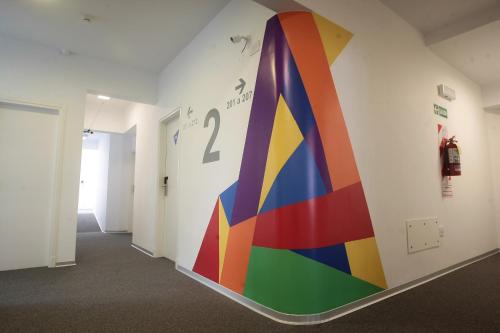 a hallway with a rainbow mural on the wall at Buen Pastor Capuchinos in Cordoba