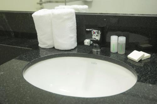 a bathroom counter with a sink with towels and a mirror at Buen Pastor Capuchinos in Cordoba