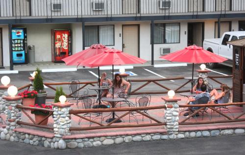 a group of people sitting at a table with umbrellas at Gateway Inn and Suites in Salida