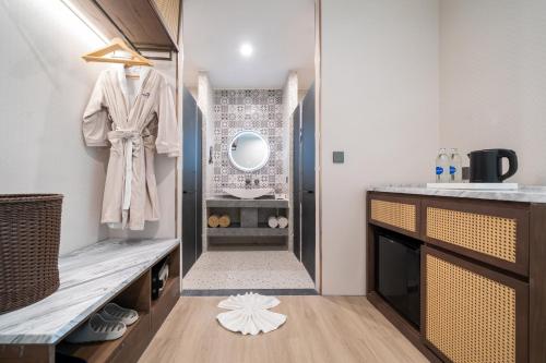 a bathroom with a robe hanging on a wall at Howard Johnson by Wyndham Phuket Naiyang in Thalang