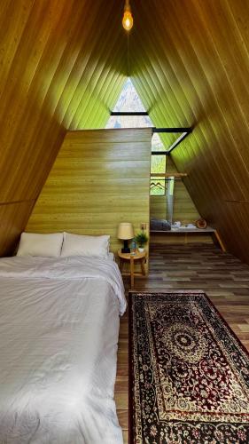 a bedroom with a bed and a rug and a window at Fortyard Cottages Hunza in Karimabad Hunza