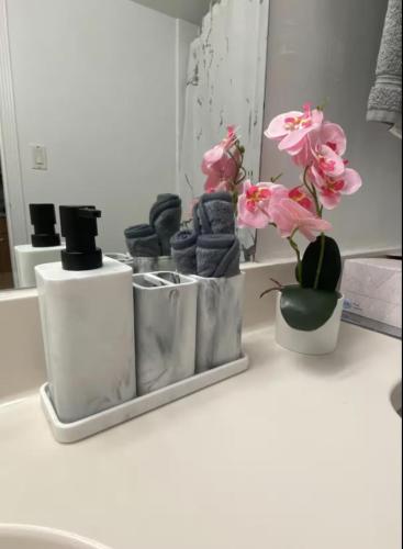 a bathroom counter with some towels and flowers on it at Pet Friendly Studio Beach and Pool Access, gym ! in Sunny Isles Beach