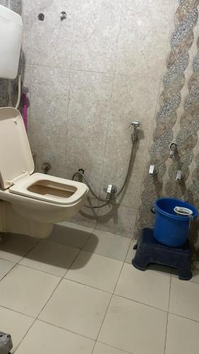 a bathroom with a toilet and a bucket at Home Stay - Maa Kaamal Deep in Surat