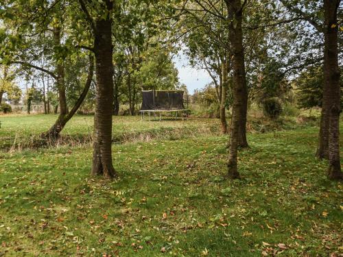 a picnic table in the middle of a field with trees at The Retreat - Uk48231 in Tibenham