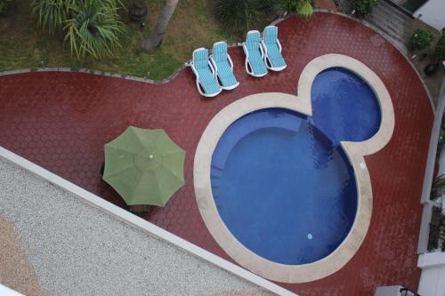an overhead view of a swimming pool with an umbrella at Seven Crown Express & Suites by Kavia in Cabo San Lucas