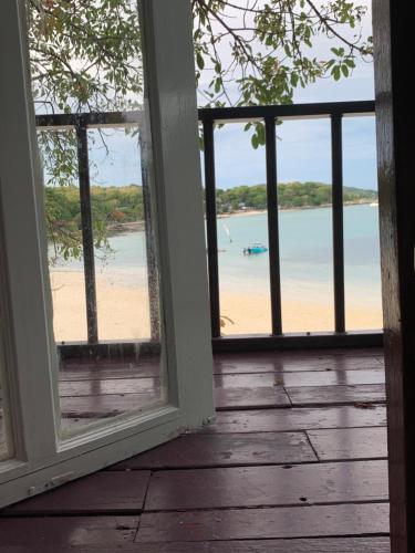 an open window with a view of a beach at Koh Samed Lung Dam Hutbeach in Ao Phutsa