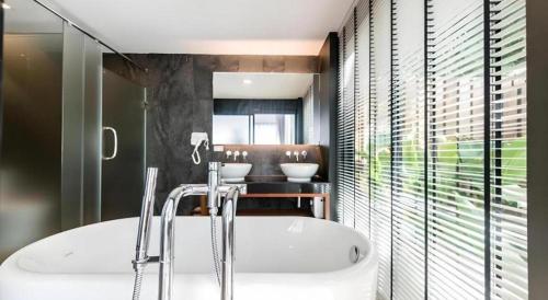 ein Badezimmer mit Badewanne und einem Tisch mit zwei Waschbecken in der Unterkunft Mira Residence & Resort (halal) in Chiang Mai
