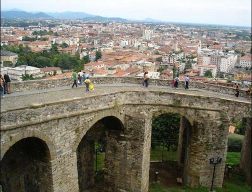 a group of people standing on top of a stone bridge at Donizetti Royal in Bergamo