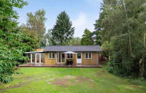 a wooden house with a large yard at Two-Bedroom Holiday Home In Liseleje in Liseleje