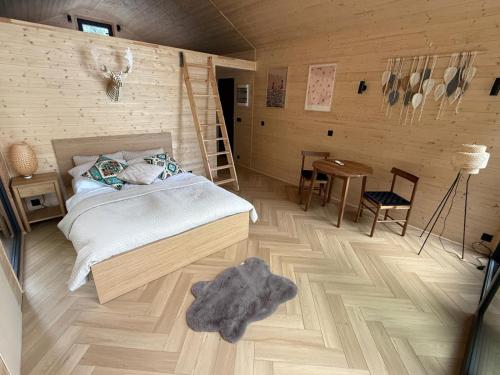 a bedroom with a bed and a wooden floor at Domki modułowe przy plaży in Sokole-Kuźnica